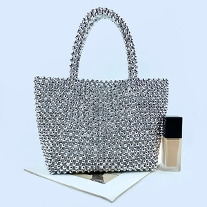 Detail shot of a silver beaded evening tote bag with shiny metallic mesh texture