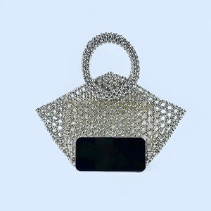 Detailed view of silver beaded basket bag with circular handle and internal lining