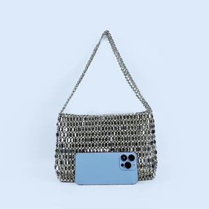 Silver sequin shoulder bag shown with a mobile phone for size reference and scale