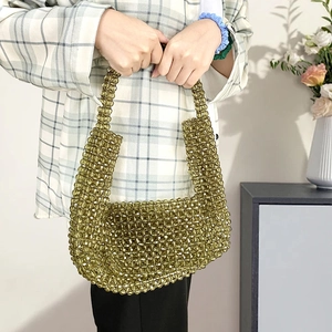 Detailaufnahme der olivgrünen Perlen-Handtasche mit gewebter Klappe und langem Griff