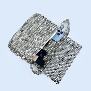 Detail of silver beaded mesh bag interior showing capacity for smartphone and lipstick