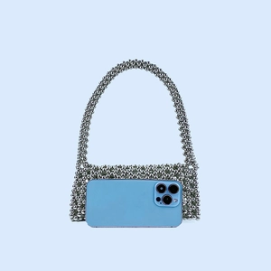 Détail du sac argenté en perles fait main avec rabat ajouré et texture métallique brillante