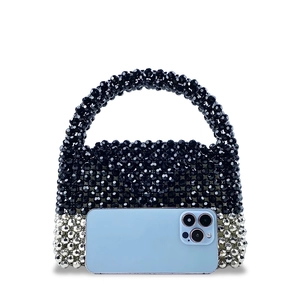 Detail view of handcrafted beaded handbag in black and silver with phone for scale