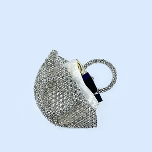 Detail view of silver beaded handbag capacity showing lipstick and compact inside