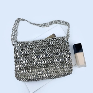 Macro shot of silver sequin woven shoulder bag showing reflective metallic disc texture