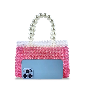 Detail of beaded handbag with pearl handle showing size compared to a smartphone