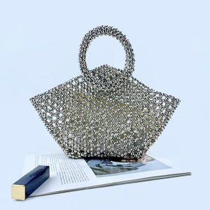 Detail of silver beaded tote bag featuring a metallic weave and round top handles