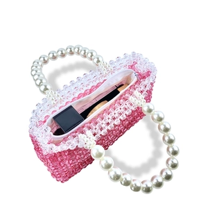 Macro view of beaded handbag interior showing pink acrylic beads and pearl handle