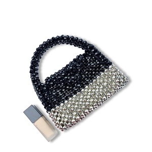 Detail of handmade beaded mini bag featuring black and silver color-block weave design
