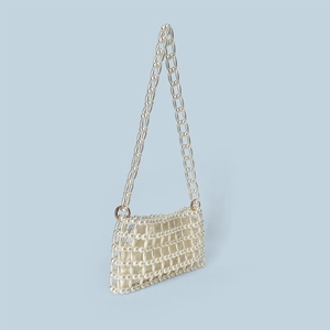 Close-up of handmade pearl beaded handbag with satin lining and gold metal rings