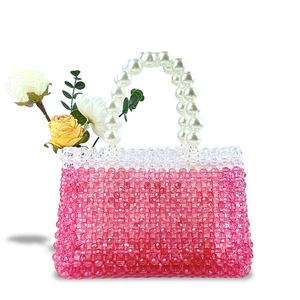 Detail view of handmade beaded handbag with pink gradient beads and white pearl handle