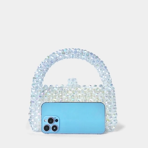Sac à main artisanal en perles irisées avec un smartphone pour référence de taille