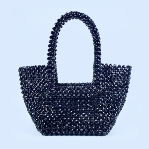 Detailed view of the handcrafted black beaded tote bag with a glossy woven texture