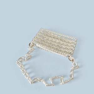 Macro detail of handmade pearl beaded mini bag showing gold zipper and woven texture