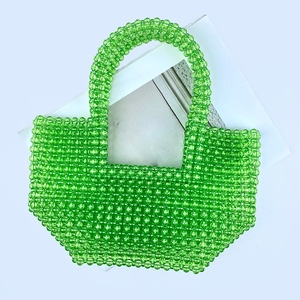 Detailed top view of handmade emerald green clear acrylic beaded tote bag on white background
