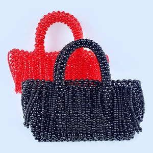 Détail de sacs à main tissés à la main en rouge et noir avec texture perlée unique