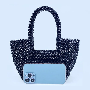 Detailed view of handmade black beaded handbag showing woven texture and interior capacity