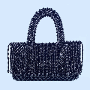 Détail du sac cabas en perles noires tissé main avec perles brillantes et pompon à franges