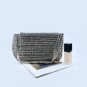 Close-up of handmade silver beaded flap bag with metallic bead texture and chain strap