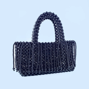 Détail d'un sac à main en perles noires avec tissage à la main et élégantes franges