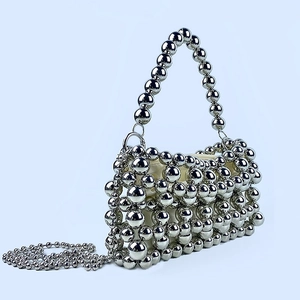 Détail du sac à perles en métal argenté avec structure tissée et doublure en tissu
