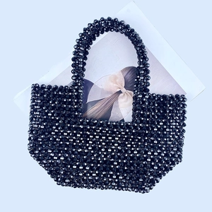 Macro shot of the black beaded handbag showing the intricate handmade grid texture