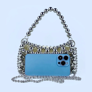 Détail du sac à perles argentées montrant la capacité du téléphone et la doublure