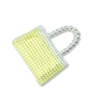 Detail of handmade beaded handbag showing gradient texture and faux pearl handle grip