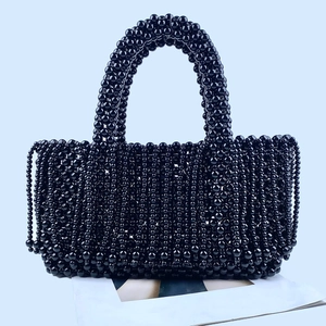Gros plan sur un sac à main en perles noires brillantes avec tissage fait main détaillé
