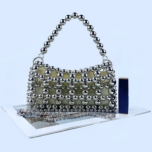 Détail du sac à main en perles argentées avec doublure en satin et bandoulière