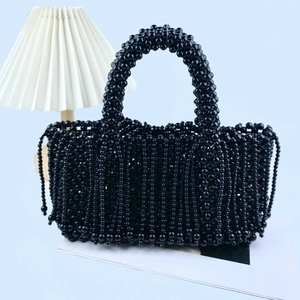 Vue détaillée d'un sac à main noir en perles fait main avec franges et anses tressées