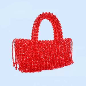 Détail d'un sac à main rouge en perles fait main avec franges et texture tissée élégante