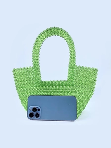 Green acrylic beaded tote bag with translucent pearls shown with phone for scale