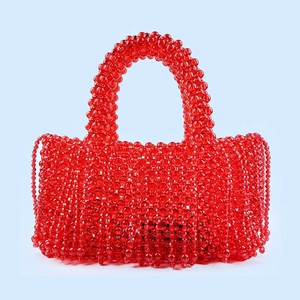 Détail du sac à main rouge fait main en perles avec glands et perles en résine translucide