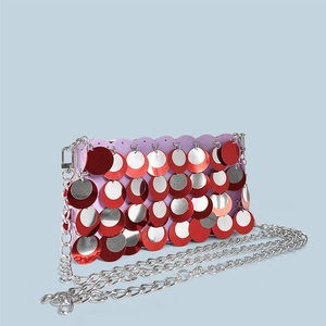 Close-up of red and silver sequins on a party clutch bag with a metallic chain strap