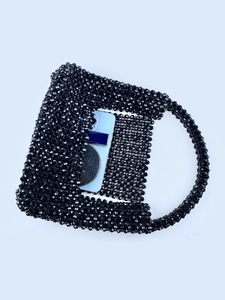 Handgefertigte schwarze Perlen-Handtasche mit langem Griff und Smartphone als Maßstab
