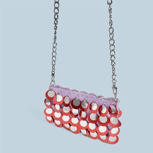 Close-up of red and silver sequins with metallic fish scale texture and chain strap