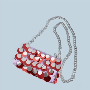Close-up of a sparkling red and silver sequin handbag with a metallic chain strap