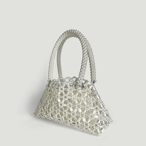 Detail of handcrafted white beaded tote bag with floral weaving and silver metal rings