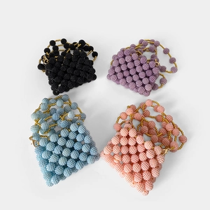 Detailed view of handmade beaded mini bags in black, purple, blue, and coral pink colors