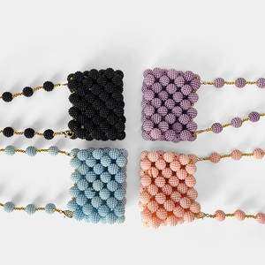 Flat lay of colorful handmade beaded mini bags with gold metal chains and textured beads