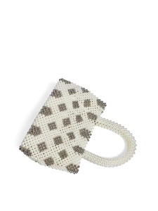 Macro shot of white handmade pearl beaded handbag with silver floral diamond pattern