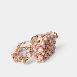 Macro detail of pink handmade beaded mini bag with textured pearls and gold accents