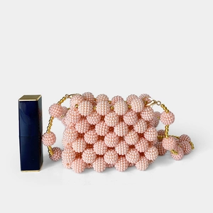 Detailed view of mini pink pearl beaded bag with lipstick for size comparison