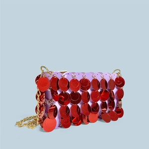 Detail of purple sequin bag with large red circular sequins and gold chain strap
