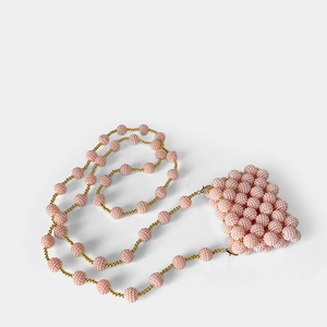 Detail of pink beaded mini bag featuring handmade pearl texture and golden lobster clasp