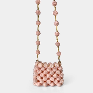 Detail of pink handmade beaded mini bag featuring intricate woven pearls and gold clasp
