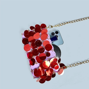Detail showing red sequins bag interior capacity with phone and lipstick items