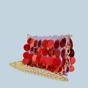 Detail view of red sequin chain bag with purple base and gold metal strap link
