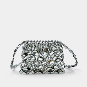 Detail of silver metallic woven mini bag featuring intricate handcrafted hollowed ring links